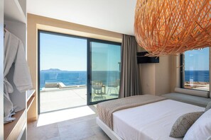 Quarto de hotel moderno com uma cama grande, varanda com vista para o mar e luminária trançada.