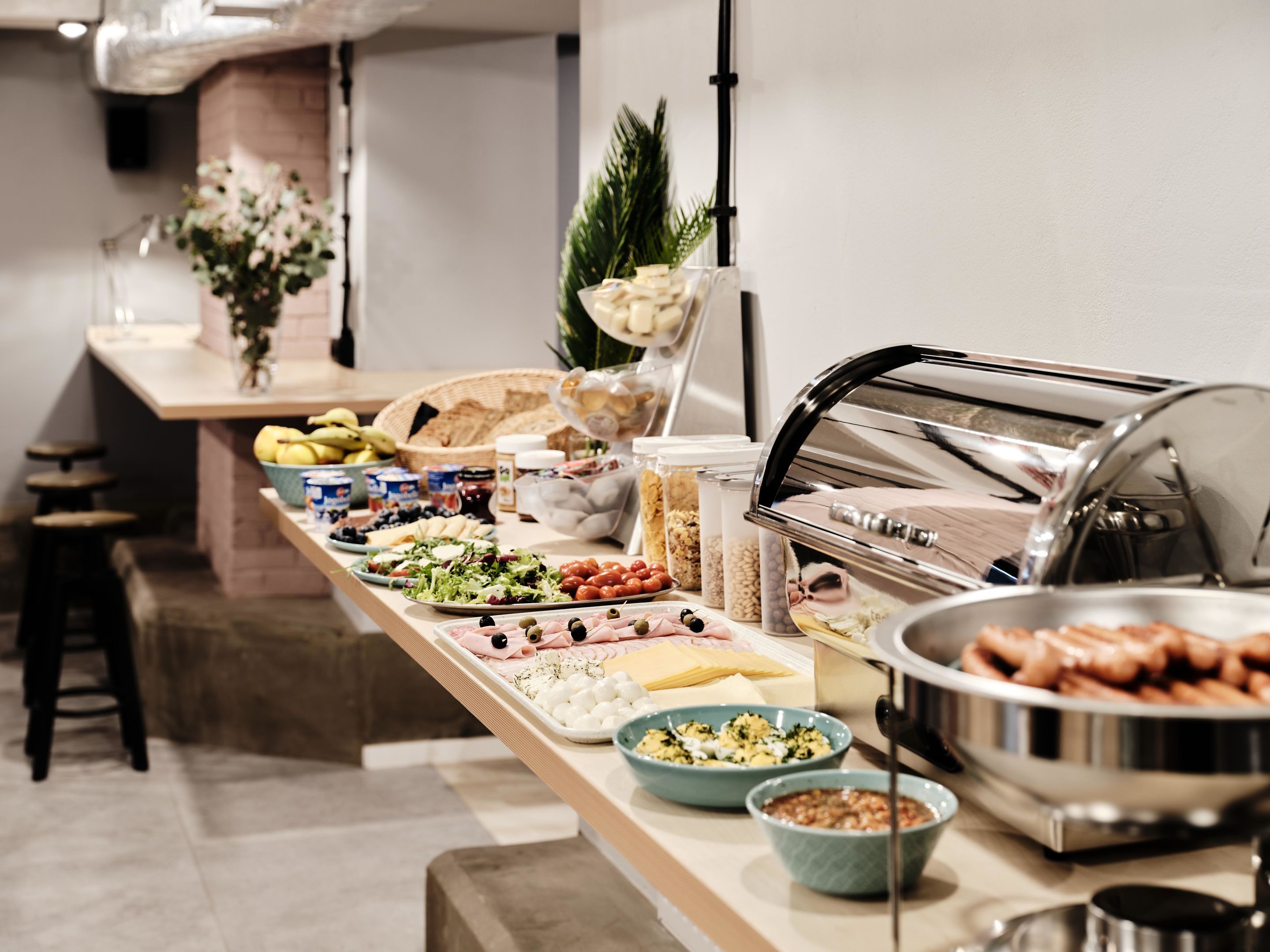 Una mesa de buffet con diversos alimentos, como frutas, quesos y ensaladas.