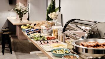 Una mesa de buffet con diversos alimentos, como frutas, quesos y ensaladas.