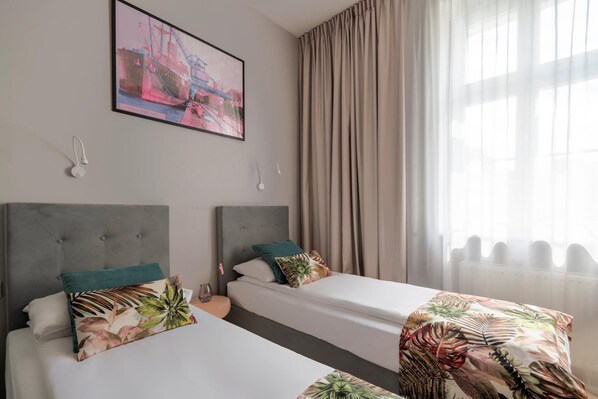 A hotel room with two beds, a large window with curtains, and a painting on the wall. - Hola Gdynia (Gdynia)