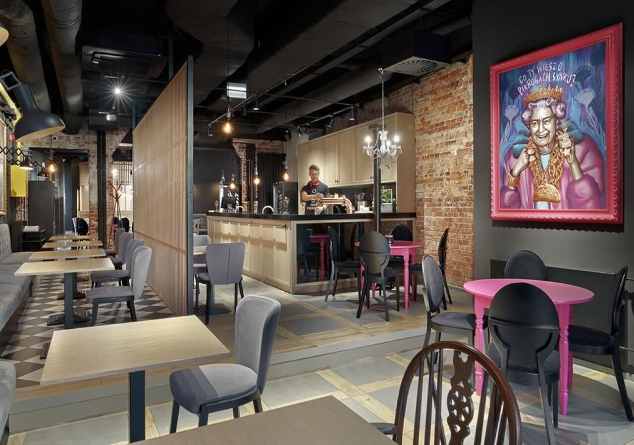 Ein modernes Restaurant mit Barbereich, Holztischen und -stühlen.