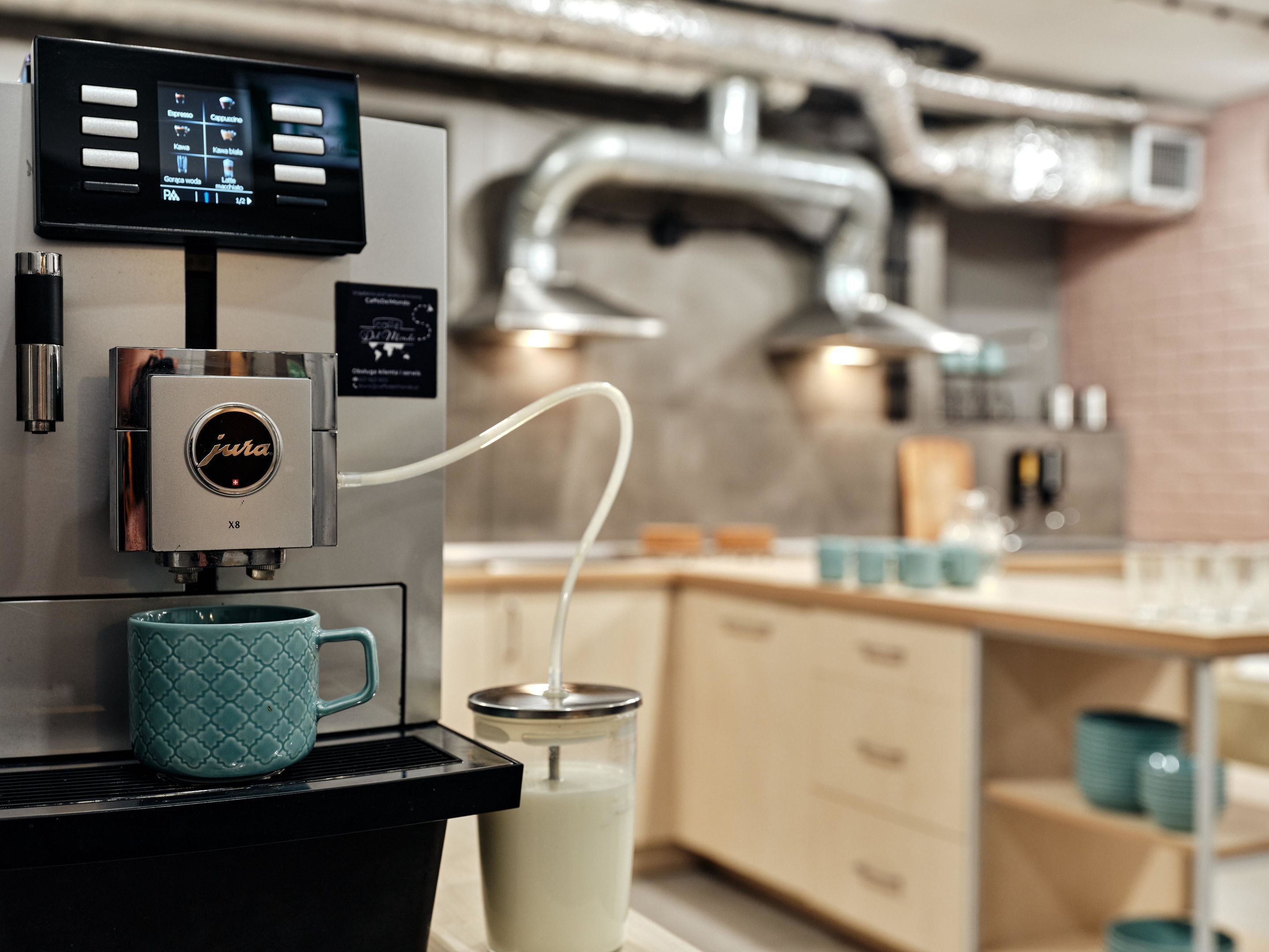 A coffee machine with a digital display, a milk frother, and a milk jug.