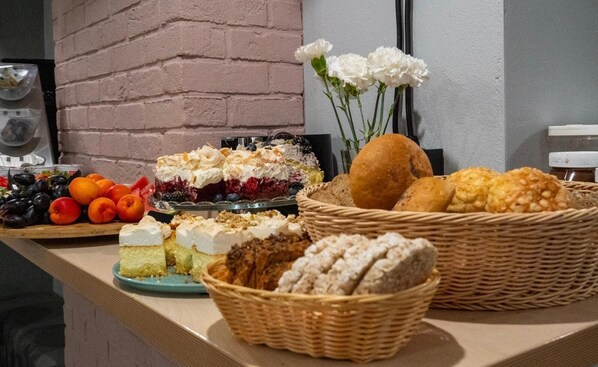 A buffet table with various desserts, fruits, and bread baskets. - Hola Gdynia (Gdynia)