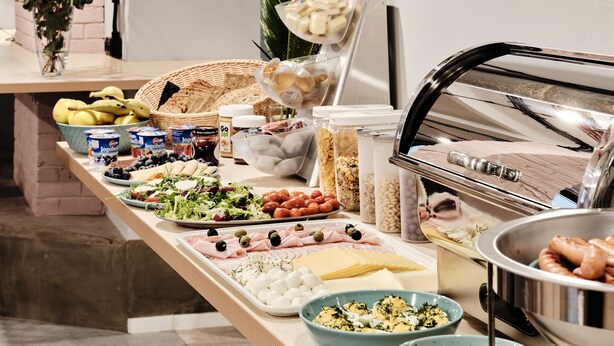 A buffet table with various food items including fruits, cheeses, meats, and salads. - Hola Gdynia (Gdynia)