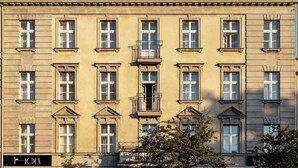 A multi-story building with a symmetrical facade, large windows, and a central balcony. - Hola Gdynia (Gdynia)