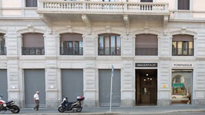 Un edificio de estilo arquitectónico clásico, con un balcón y un escaparate con señalización.