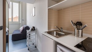 A compact kitchen with a sink, a small countertop, and a utensil holder.