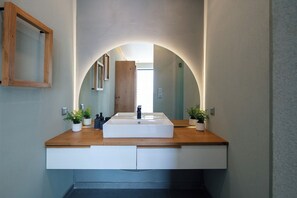 Features a sleek sink, large mirror, and ample natural light.