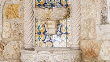 A stone wall with a decorative tile archway.