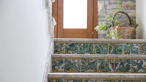Una escalera con baldosas de diseño ornamentado en tonos verde y amarillo.