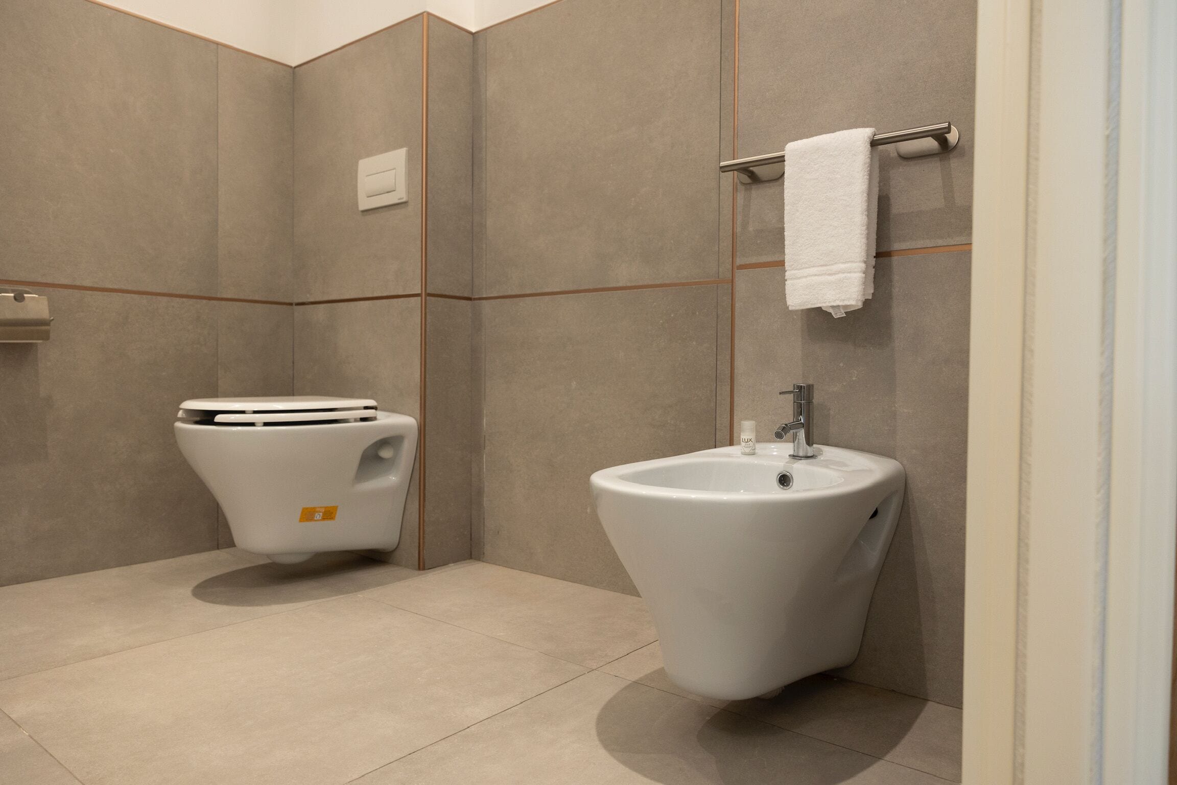 Un baño moderno con inodoro, bidé y lavamanos.