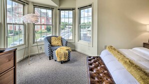 A bedroom with a large window, a tufted bench, a patterned armchair, and a floor lamp. - Historic Dtwn Home: 2 Mi to Military Park! (Gettysburg)