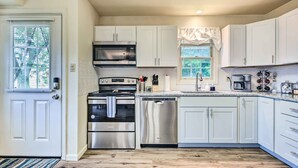 A modern kitchen with white cabinets, stainless steel appliances, and a wooden floor. - Historic Dtwn Home: 2 Mi to Military Park! (Gettysburg)