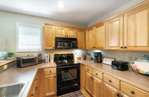 Dishwasher, coffee/tea maker, cookware/dishes/utensils, dining tables