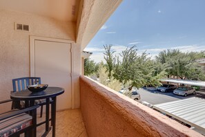 Enjoy a peaceful view from this balcony with a table and chair, perfect for taking in the surroundings.