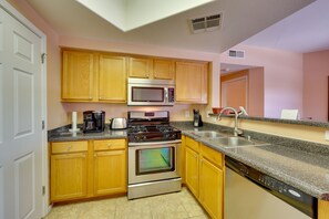 Enjoy cooking in this well-lit kitchen with a sink, microwave, stove, oven, and dishwasher.