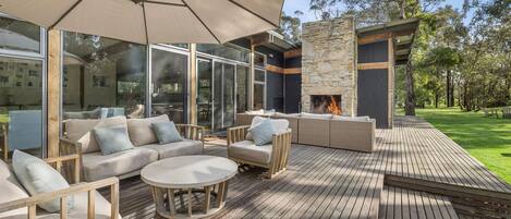 An outdoor patio with a sofa set, a round table, and a large umbrella.