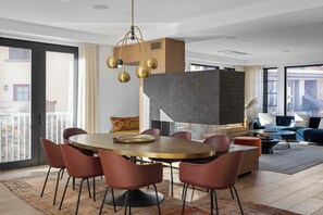 A modern dining area with a round table, red chairs, and a unique hanging light fixture. - Exceptional Residence by InvitedHome | Mountain Village Core, Family Friendly (Mountain Village)