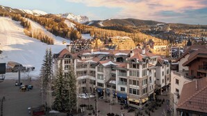 A multi-story hotel with a central courtyard, surrounded by snow-covered mountains and forested areas. - Exceptional Residence by InvitedHome | Mountain Village Core, Family Friendly (Mountain Village)