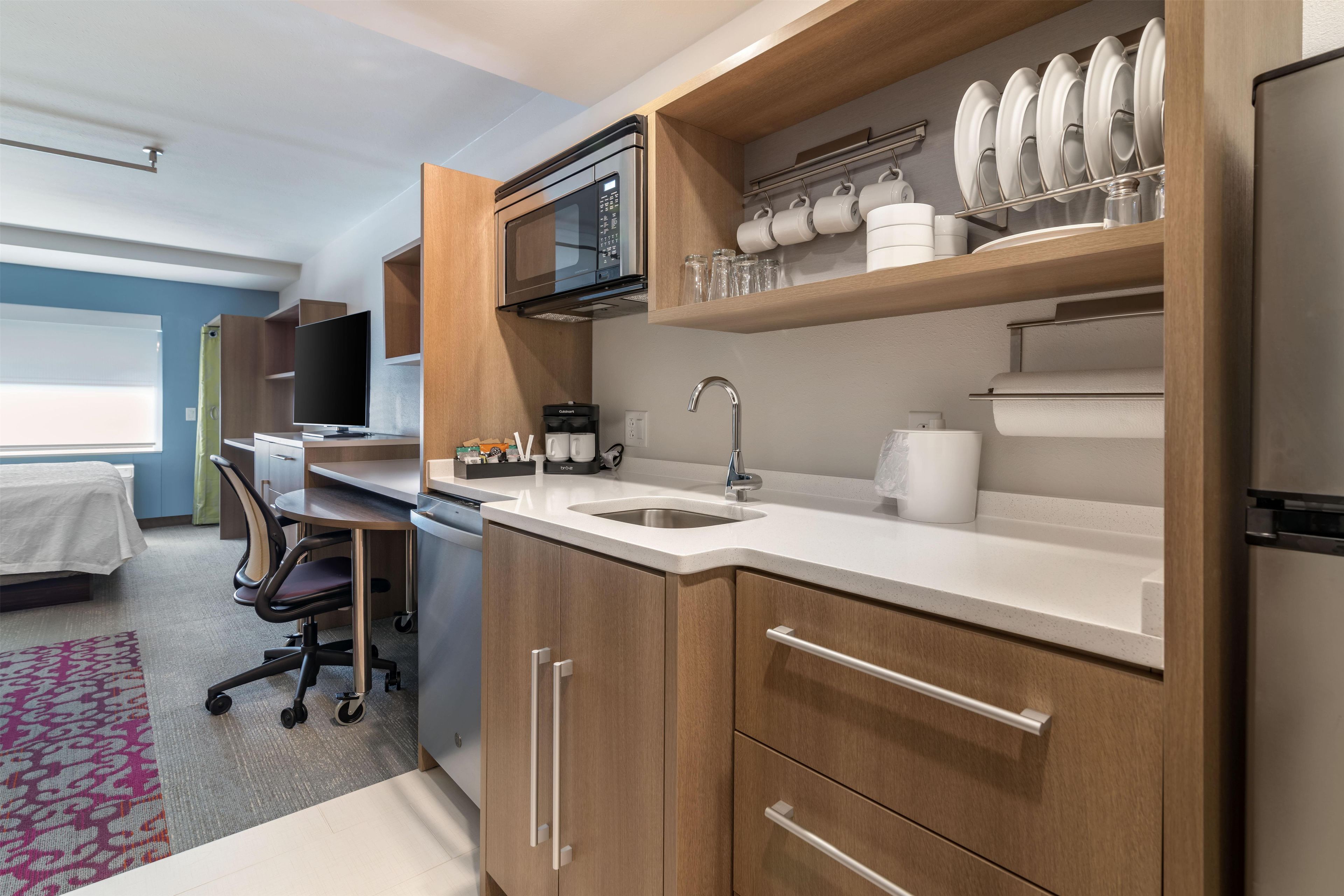 A modern kitchen with a microwave, sink, and cabinets.
