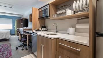A modern kitchen with a microwave, sink, and cabinets.