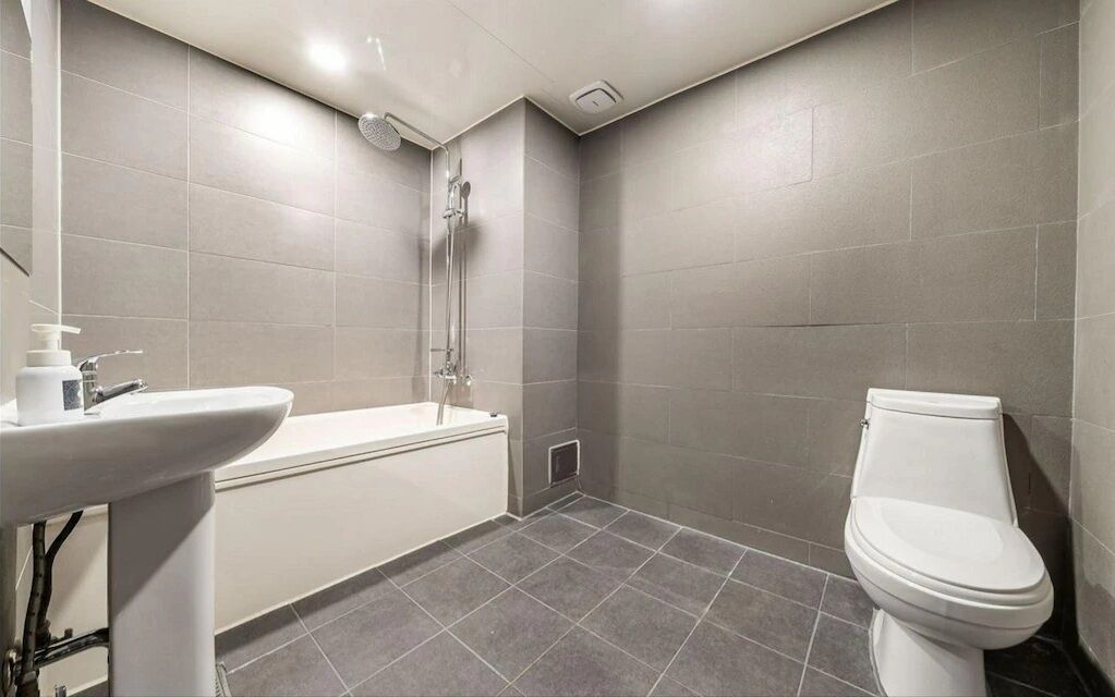 A bathroom with a bathtub, sink, and toilet.