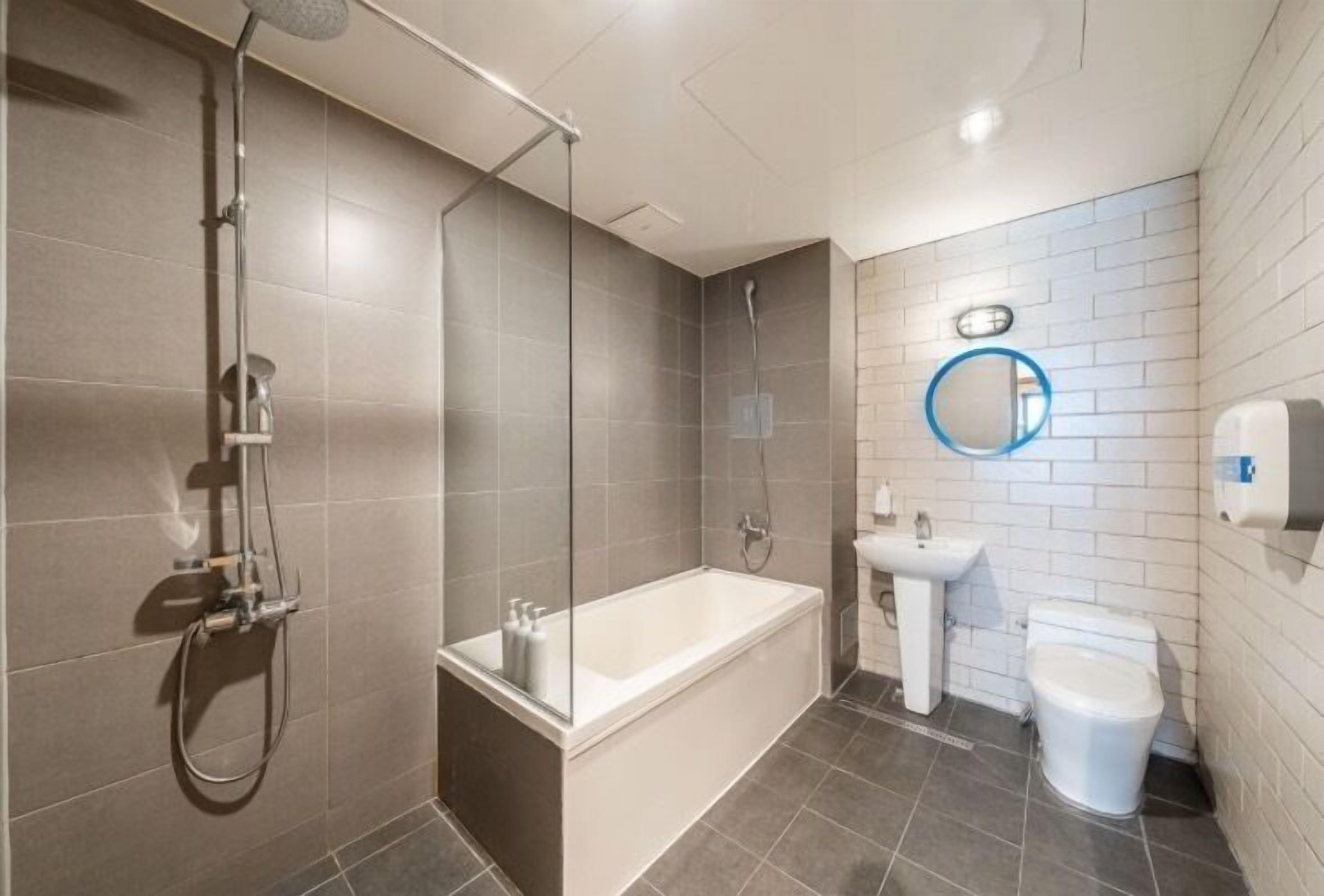 Une salle de bain moderne équipée d’une baignoire, d’une douche, d’un lavabo et de toilettes.