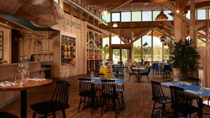 Un restaurant au décor intérieur en bois, avec de nombreuses tables et chaises.