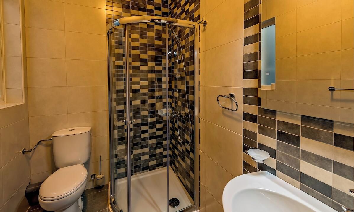 Une salle de bain avec une douche à parois de verre, des toilettes et une baignoire.