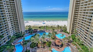 Een resort met zwembad, strand en uitzicht op de oceaan.