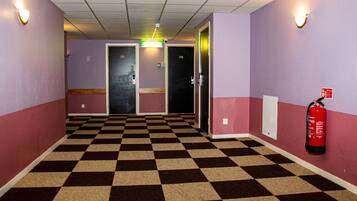 A hallway with a checkered floor, purple walls, and doors numbered 201 and 202.