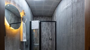 A modern bathroom with a sink, toilet, and glass-enclosed shower. - Comfort Point (Istanbul)