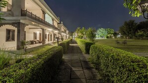 A pathway leading to a building with multiple balconies and a well-maintained garden. - Ginger Ranthambore,Sawai Madhopur (Sawai Madhopur)