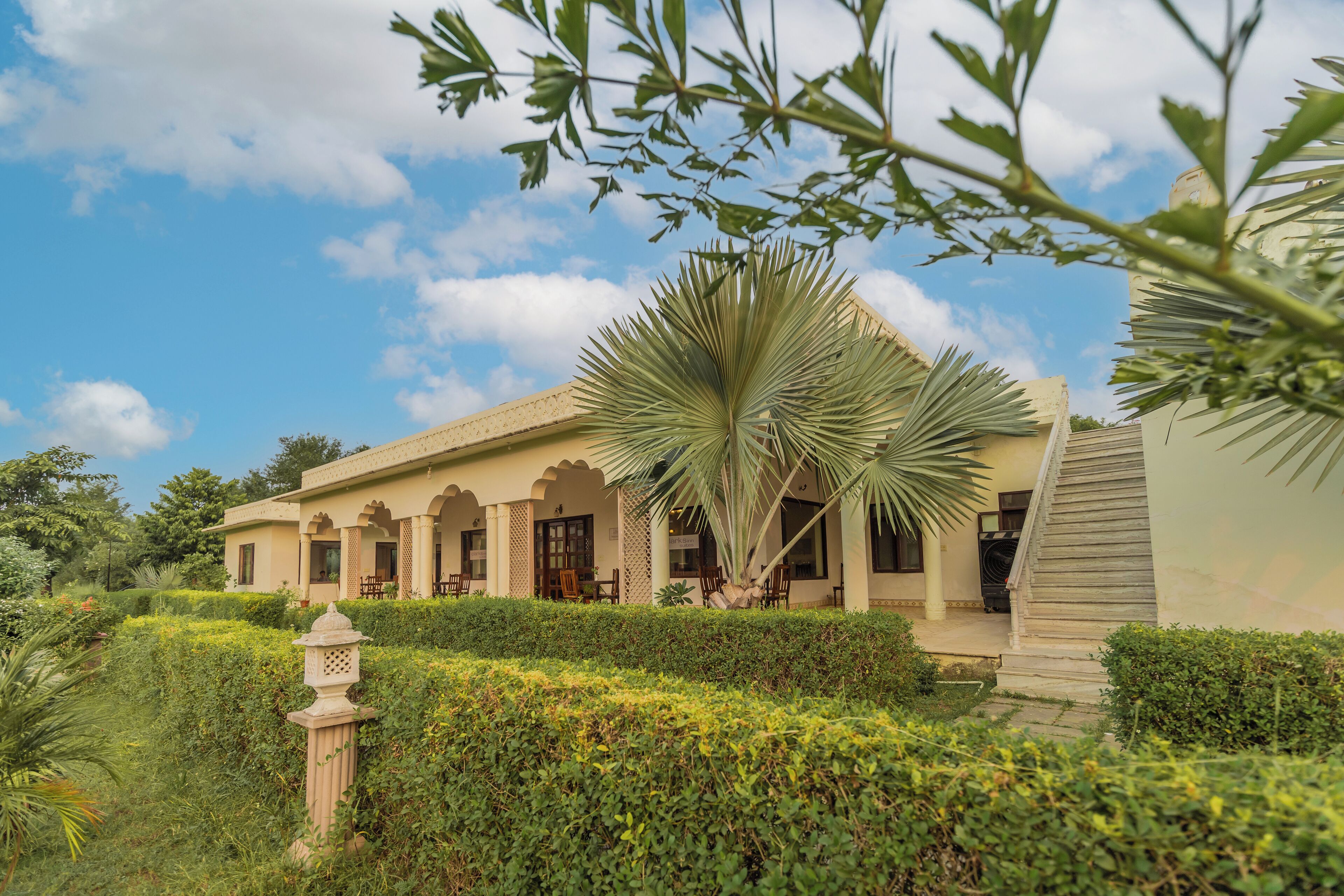 A building with a traditional architectural style, featuring arched doorways and a covered patio area.