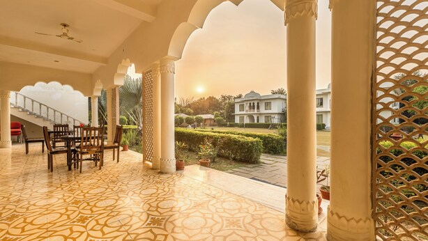 A spacious indoor area with patterned flooring, a staircase, and a view of a building through a lattice screen. - Ginger Ranthambore,Sawai Madhopur (Sawai Madhopur)