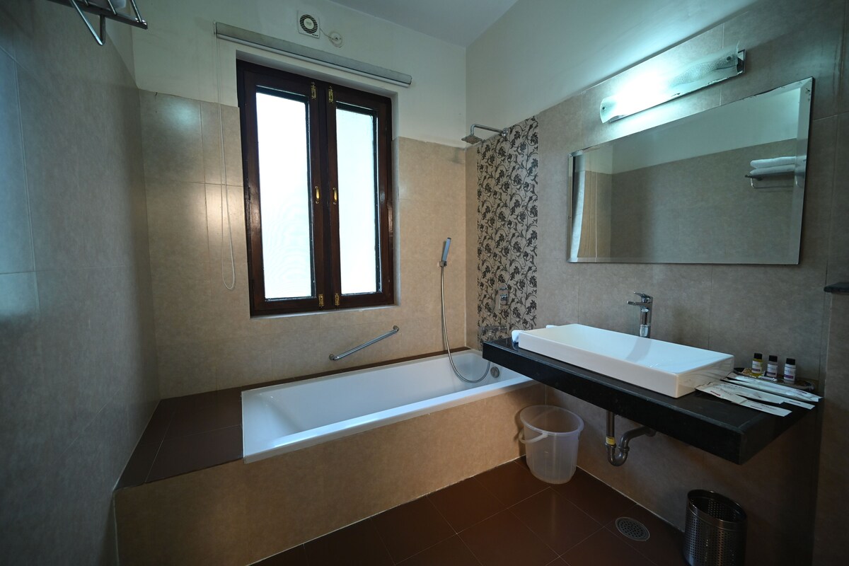 A modern bathroom with a bathtub, a large mirror, and a sink.