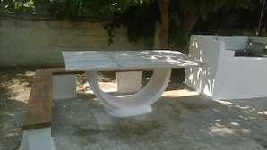 A concrete bench with a white backrest and a wooden slat on the left side. - Apartment 'Μaria's House 1' with Private Terrace, Shared Garden and Air Conditioning (Evias)