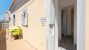 Ein Gebäude mit einem Schild, auf dem 'CASA B' steht, und einer gefliesten Terrasse mit Tisch und Stühlen.
