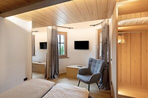 Une chambre avec un lit superposé, un bureau, une chaise et un téléviseur.