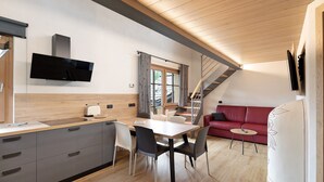 Una cocina moderna con comedor, un sofá rojo y una escalera.