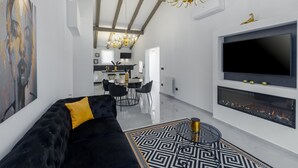 A modern living room with a black sofa, a large TV, and a fireplace. - Modern Apartment Black Diamond with balcony in Vrsar (Vrsar)