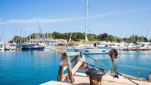A marina with multiple sailboats docked, a wooden dock, and a fishing rod. - Modern Apartment Black Diamond with balcony in Vrsar (Vrsar)