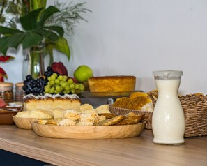 Puisesta pöydästä löytyy monenlaista syötävää, kuten leipää, leivonnaisia ja lasi maitoa.