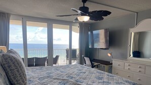 A hotel room with a bed, a desk, a chair, a TV, and a balcony with a view of the ocean. - Beachfront! Lg Balcony Amazing Gulf-Beach Views! (Panama City Beach)
