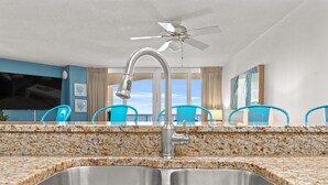 A kitchen with a granite countertop, stainless steel sink, and a ceiling fan. - Beachfront! Lg Balcony Amazing Gulf-Beach Views! (Panama City Beach)