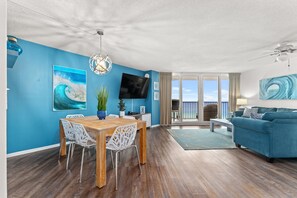Enjoy a spacious living area with a dining table, flat-screen TV, and balcony with a view.