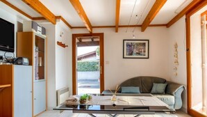 Ein modernes Wohnzimmer mit einem Glastisch, einer Couch und einer Holzbalkendecke.