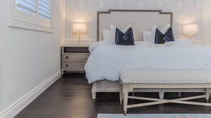 A bedroom with a bed, bedside tables, and a bench. - The Jasmine Gate (Casuarina)