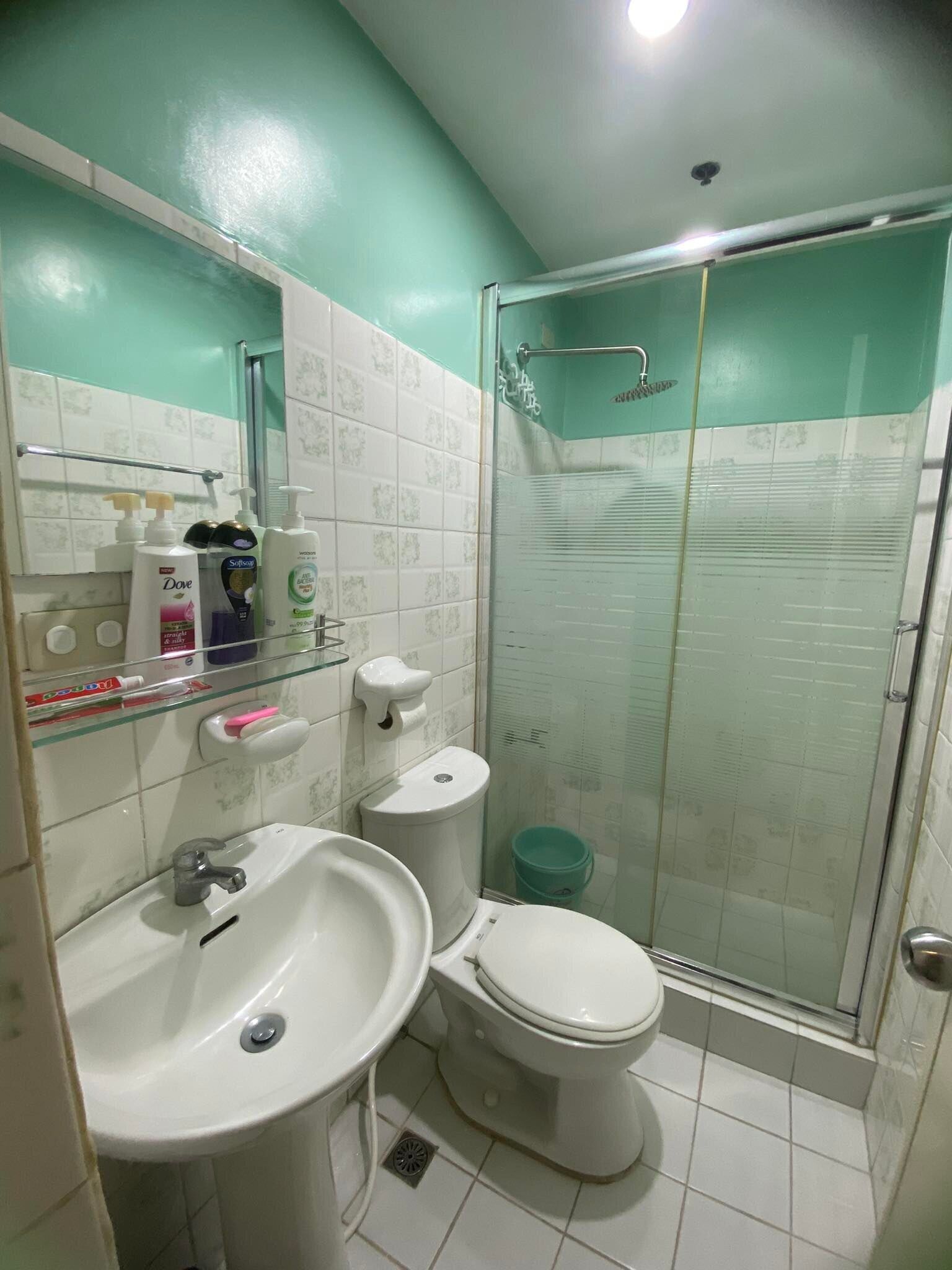 A bathroom with a sink, toilet, and glass shower enclosure.