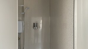A shower with a handheld showerhead and a wall-mounted control panel. - St. Peter's Shared House (Birmingham)